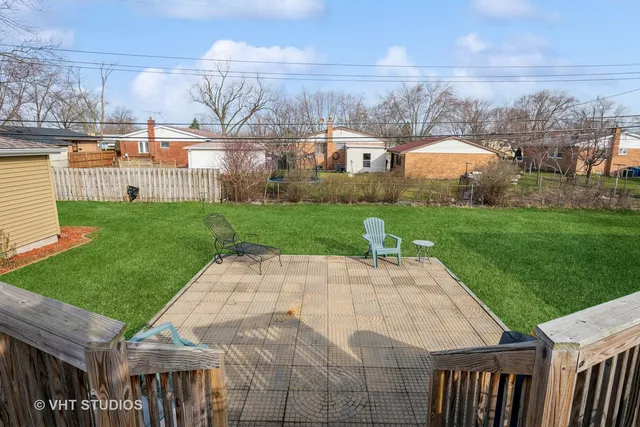a view of a backyard with couches under an umbrella