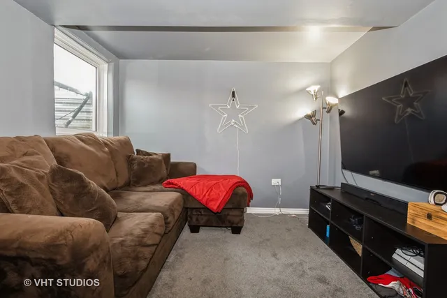 a living room with furniture a flat screen tv and a window