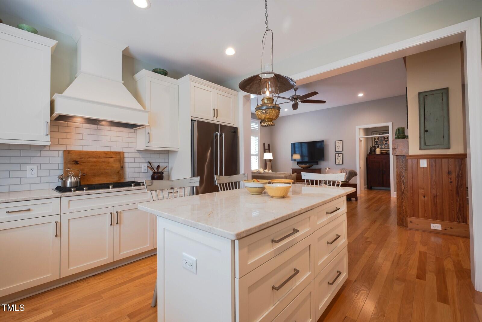 4331 Millcreek Circle Pittsboro, NC 27312 - Photo 10 of 56 a kitchen with stainless steel appliances a center island wooden floor and a view of living room