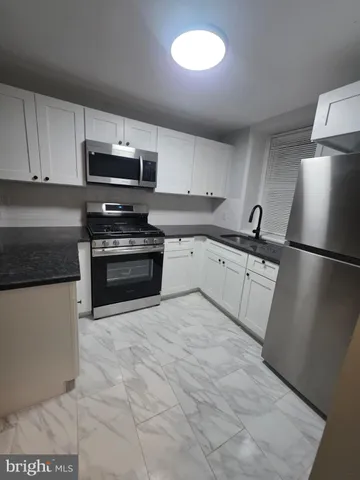 a kitchen with stainless steel appliances granite countertop a refrigerator sink and stove