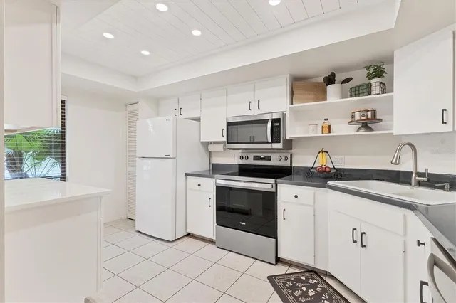a kitchen with white cabinets sink and white appliances