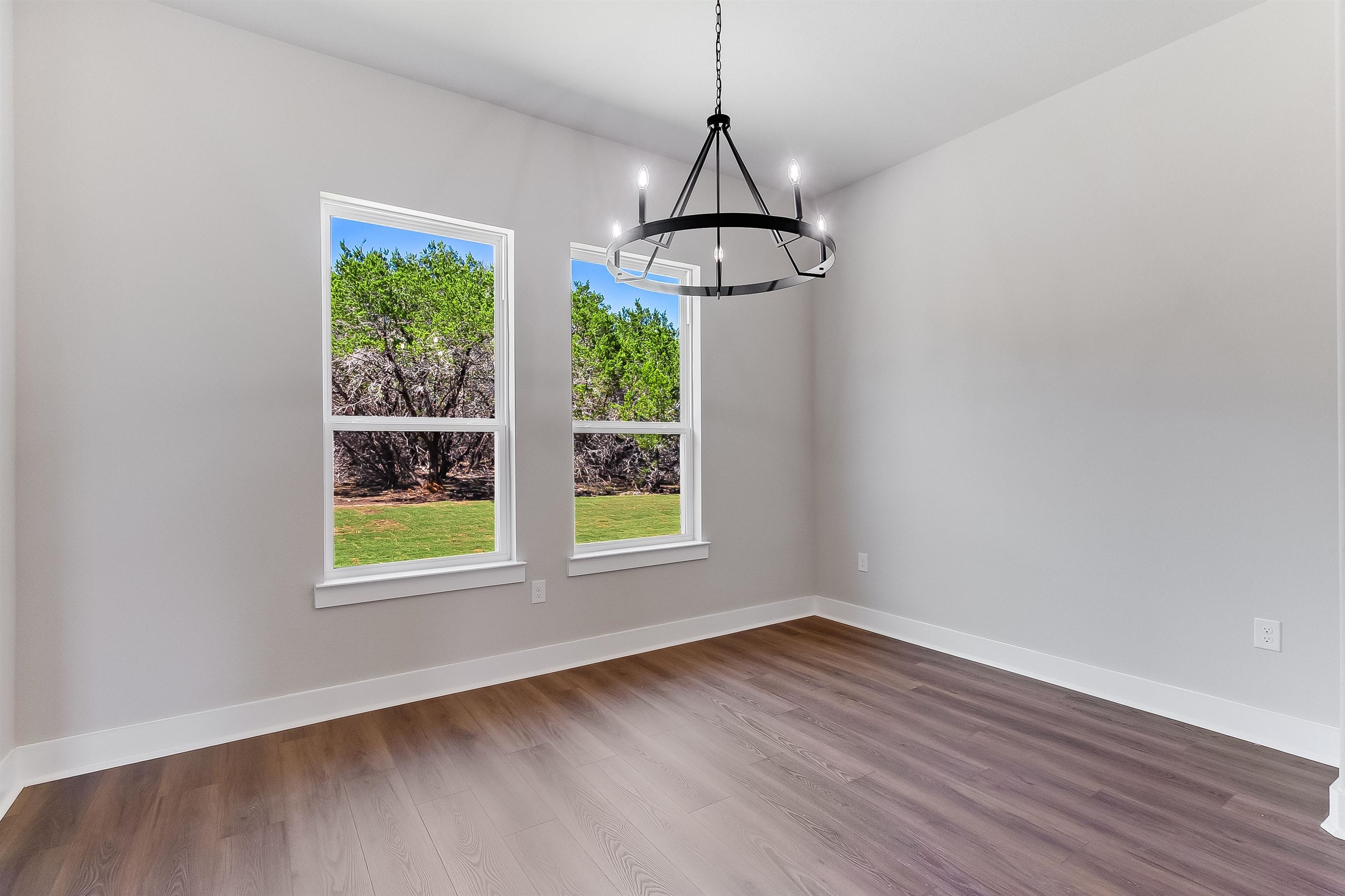 118 Rosebud Rnch Road Bertram, TX 78605 - Photo 7 of 23 a view of an empty room with wooden floor and windows