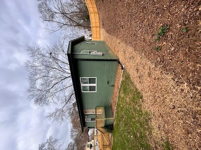 a view of a house with backyard and trees