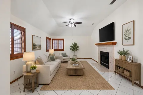 a living room with furniture a flat screen tv and a fireplace