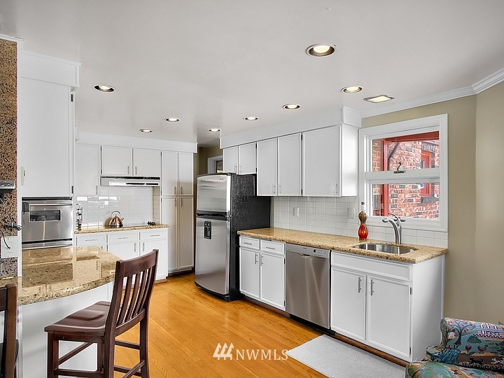 3015 West Viewmont Way West Seattle, WA 98199 - Photo 6 of 15 a kitchen with white cabinets and stainless steel appliances