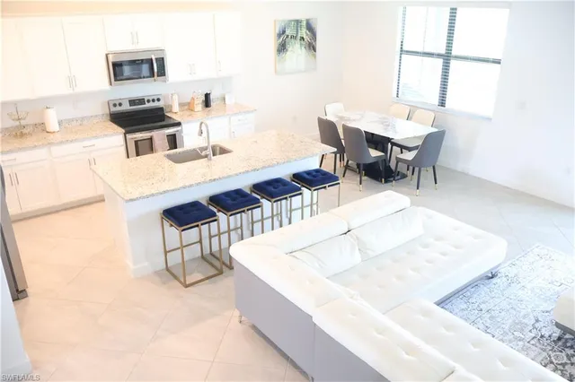 a living room with stainless steel appliances kitchen island granite countertop furniture and a fireplace