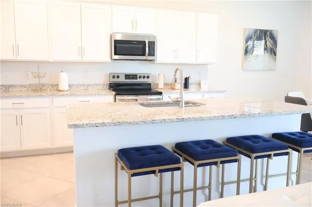 a kitchen with stainless steel appliances granite countertop a stove a sink and a microwave