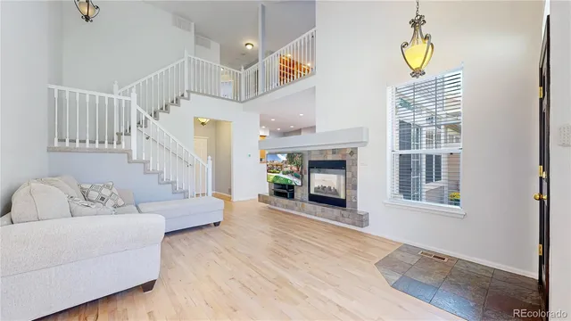 a living room with furniture a fireplace and wooden floor