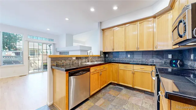 a kitchen with stainless steel appliances granite countertop a stove a sink and a microwave