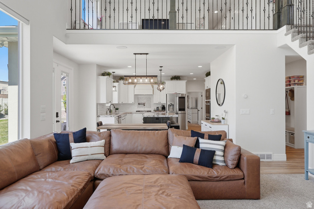 10676 Urban Rdg Cove South Jordan, UT 84095 - Photo 6 of 48 Open-concept living area with a two-story ceiling and an upper-level wrought iron balcony