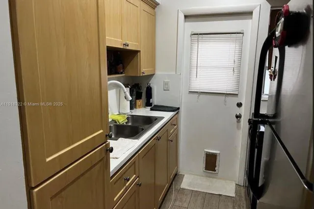 a kitchen with a sink a refrigerator and cabinets