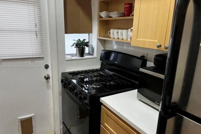 a kitchen with a stove and white cabinets