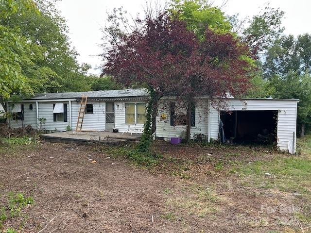 a front view of house with yard and trees in the background