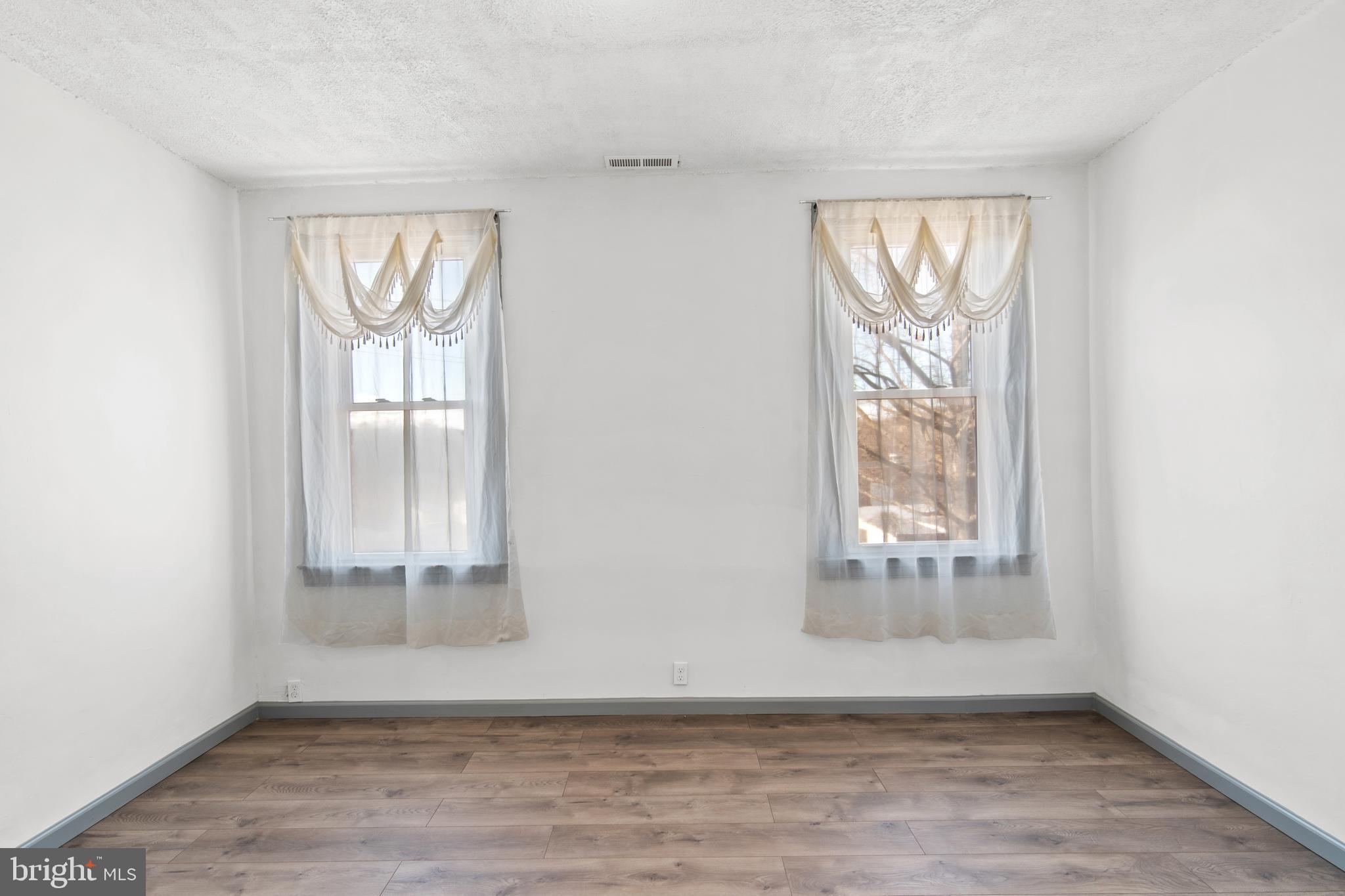 941 Brunswick Street Baltimore, MD 21223 - Photo 18 of 35 an empty room with wooden floor and windows