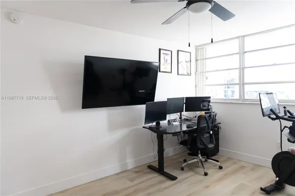 a view of a workspace with furniture and a window