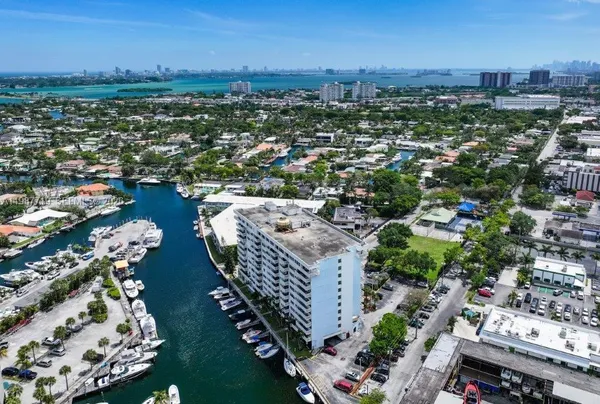 an aerial view of a city with lots of residential buildings ocean and mountain view in back