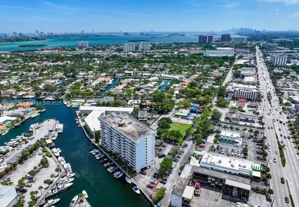 an aerial view of a city with lots of residential buildings ocean and mountain view in back