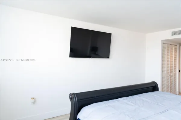 a bedroom with a bed and a tv