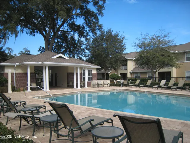 a view of a patio with table and chairs potted plants and large tree