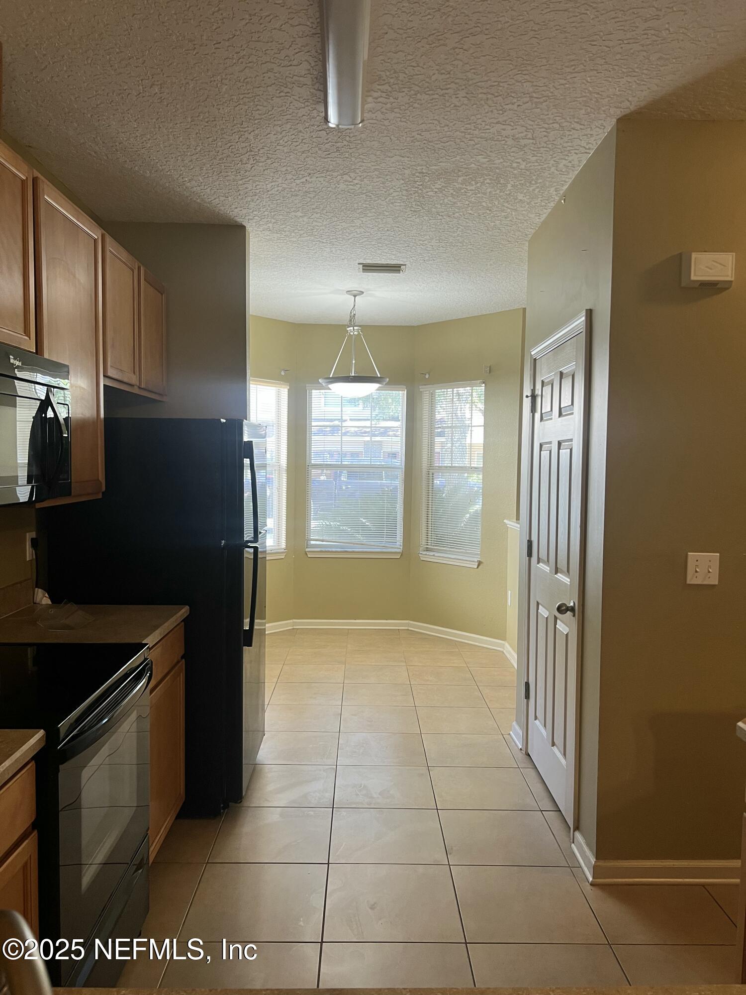 5663 Greenland Road, Unit 1706 Jacksonville, FL 32258 - Photo 2 of 11 a kitchen with stainless steel appliances granite countertop a refrigerator and a stove top oven