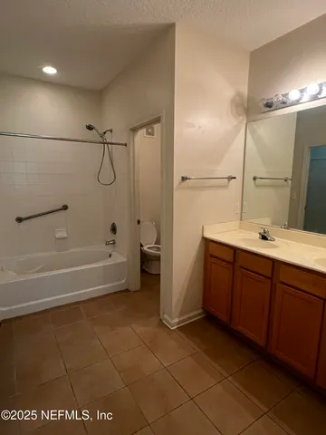 a bathroom with a tub sink vanity and a mirror