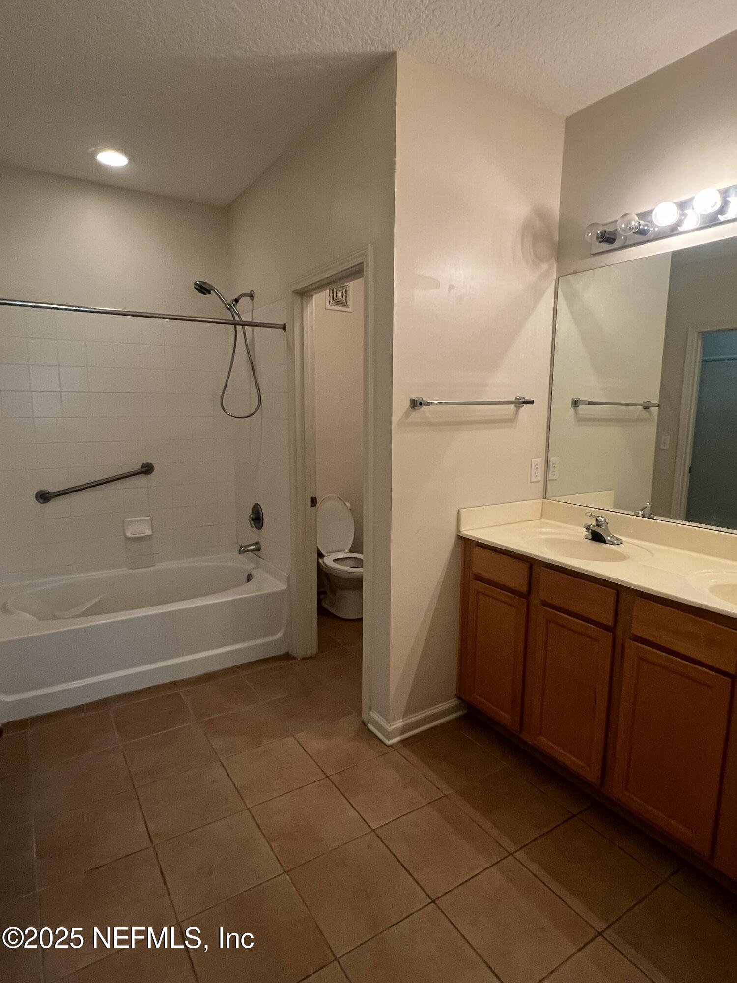 5663 Greenland Road, Unit 1706 Jacksonville, FL 32258 - Photo 5 of 11 a bathroom with a tub sink vanity and a mirror