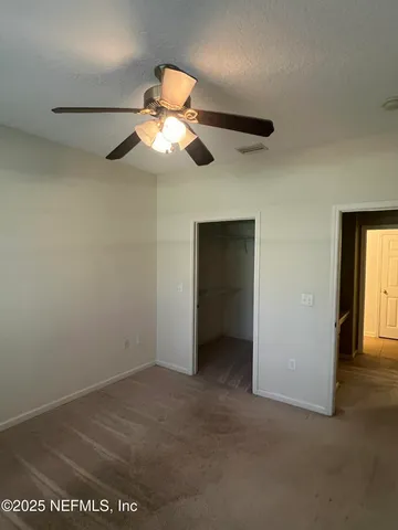 en empty room with windows and fan