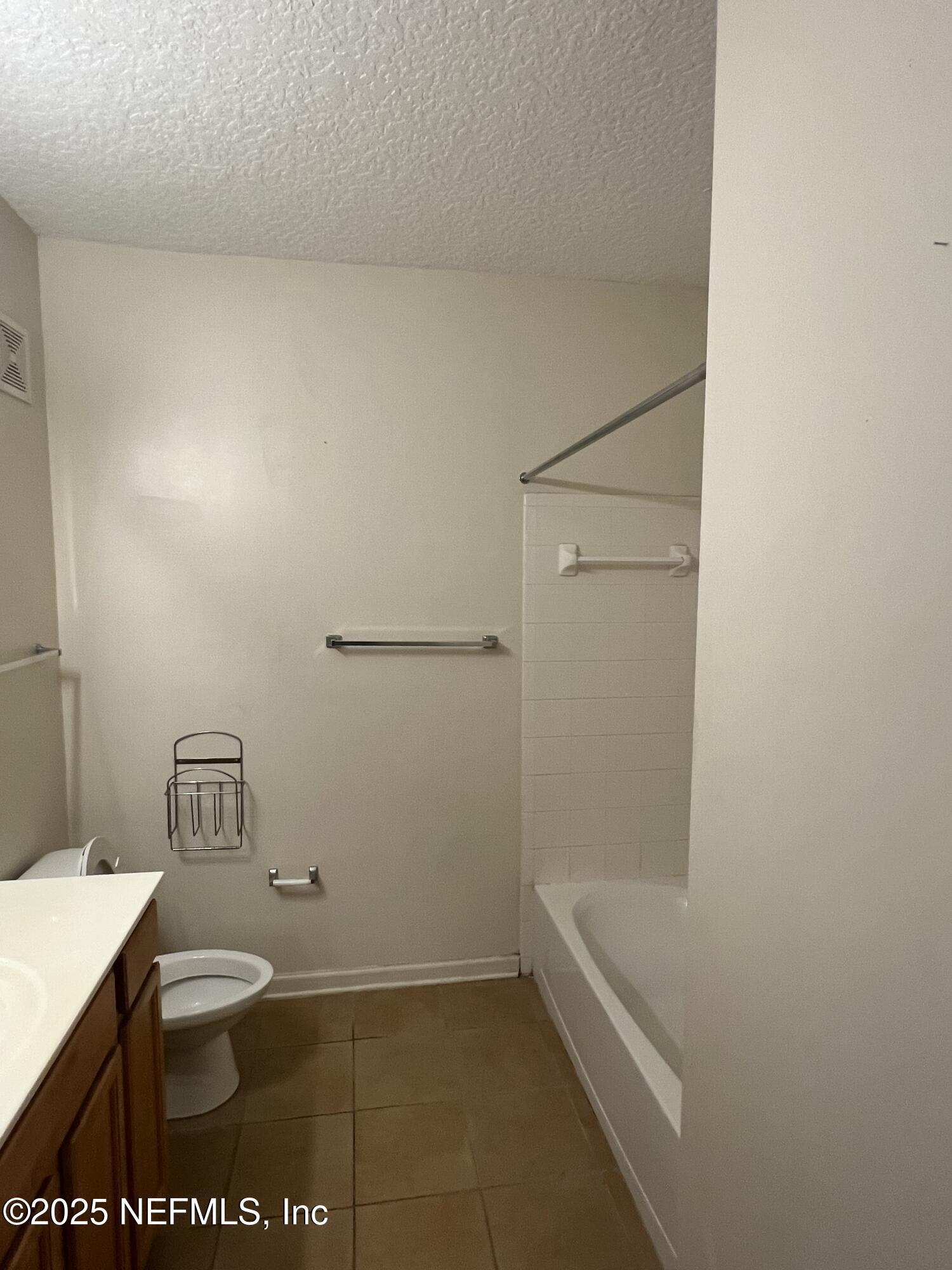 5663 Greenland Road, Unit 1706 Jacksonville, FL 32258 - Photo 9 of 11 a bathroom with a granite countertop toilet and a shower