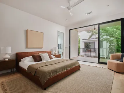 a bedroom with bed and glass window