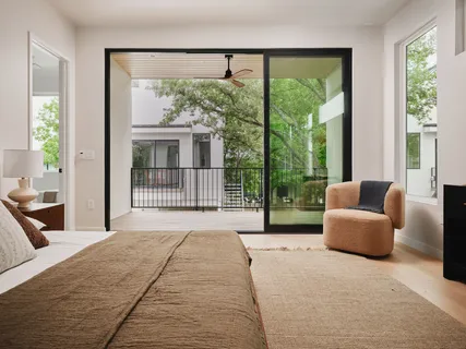 a bedroom with furniture and a large window
