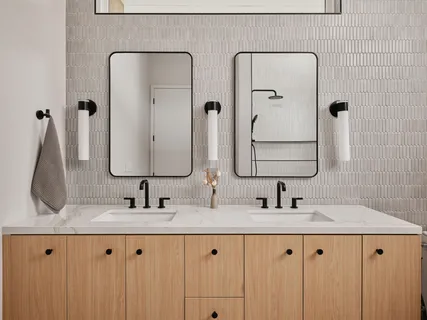 a bathroom with double vanity sinks and a mirror