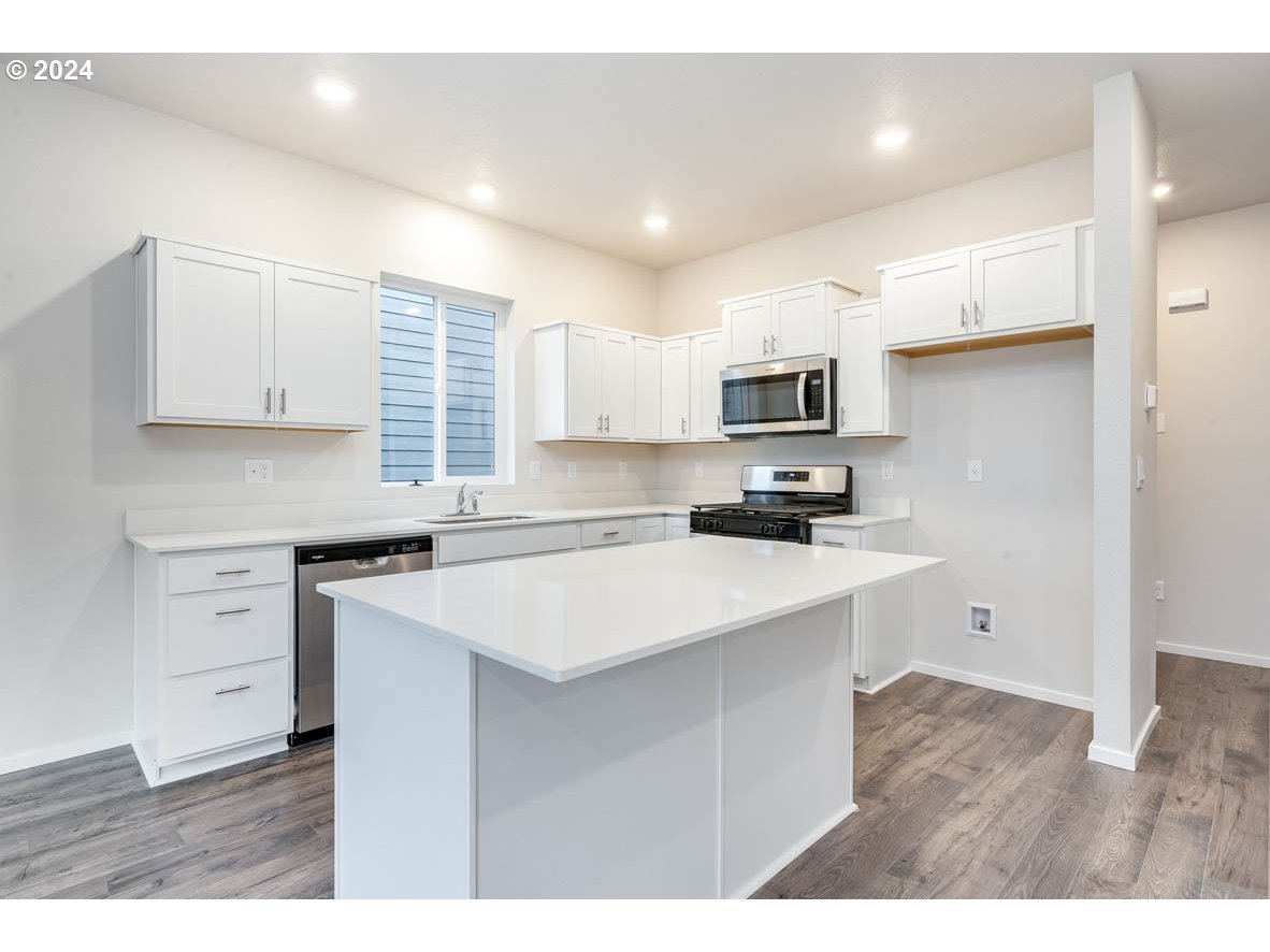 2998 U Street Springfield, OR 97477 - Photo 3 of 16 a kitchen with a stove a sink and a refrigerator