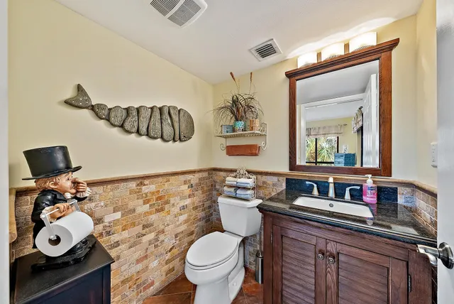 a bathroom with a toilet a sink and mirror
