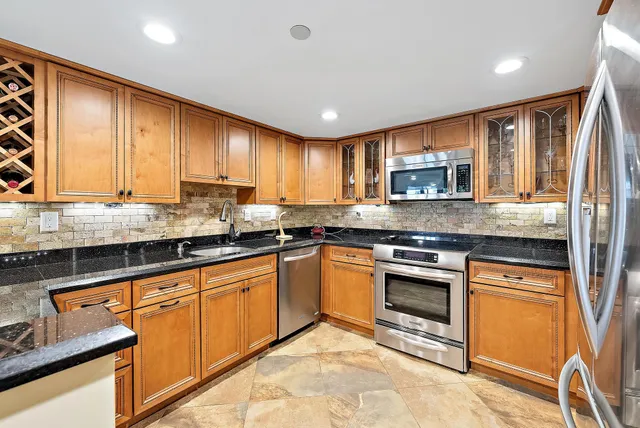 a kitchen with stainless steel appliances granite countertop a stove sink and cabinets
