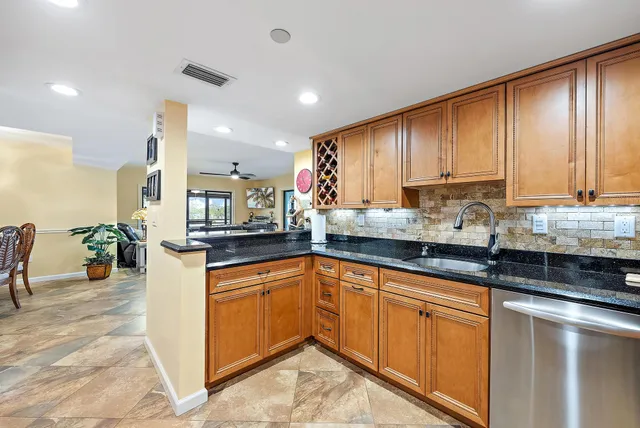 a kitchen with stainless steel appliances granite countertop a sink stove and cabinets