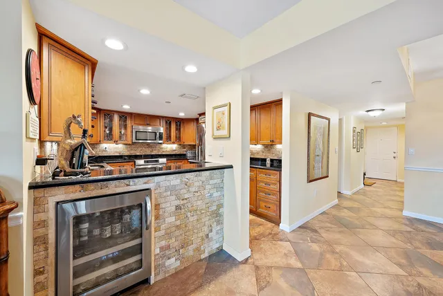 a kitchen with stainless steel appliances granite countertop a stove refrigerator and cabinets