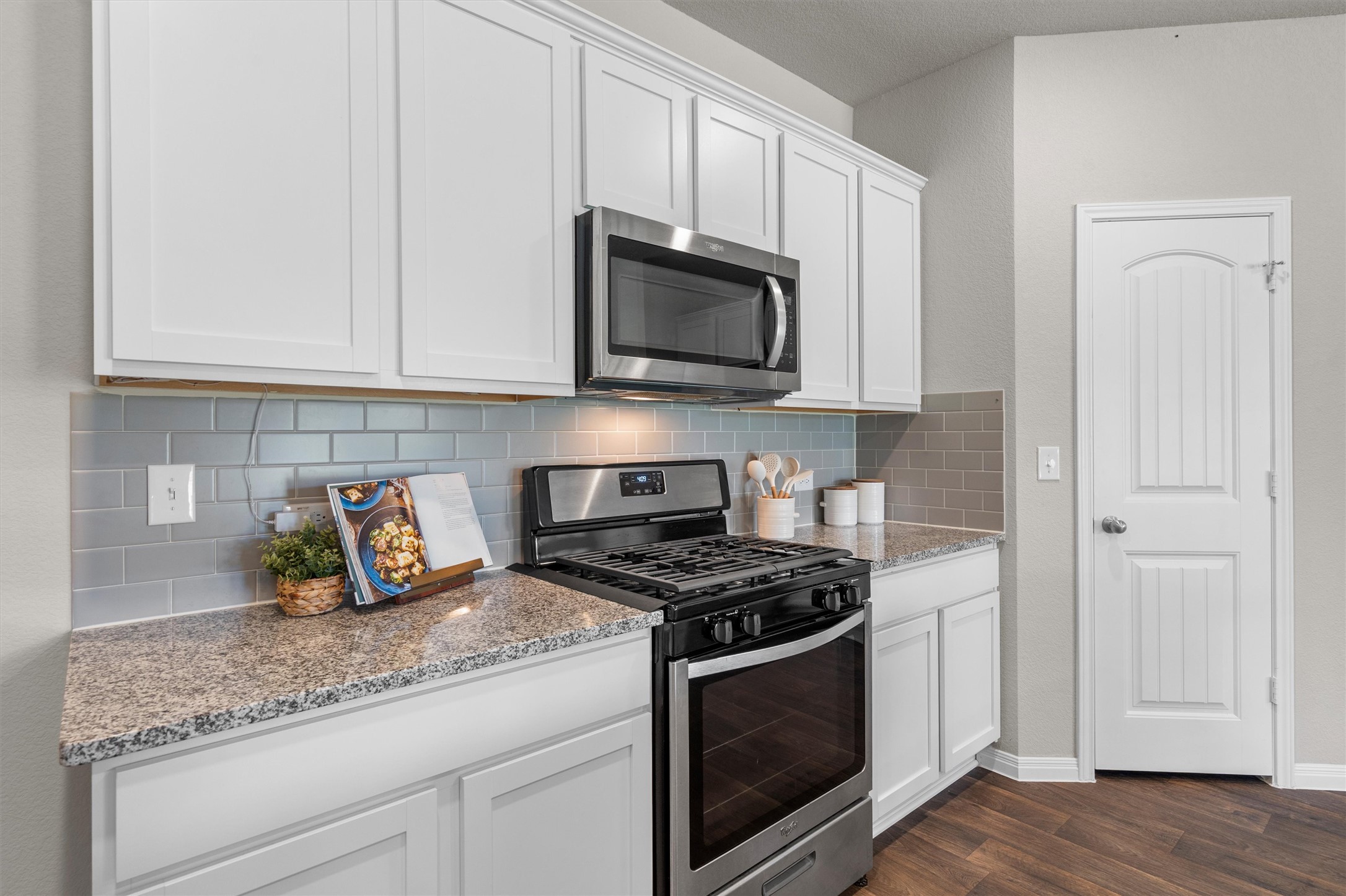 19525 Abigail Fillmore Road Manor, TX 78653 - Photo 10 of 38 Culinary delights await in this modern kitchen with granite counters and rich wood-look flooring.