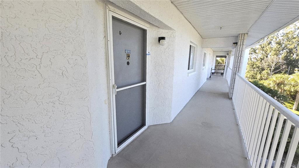 1401 South McCall Road, Unit 301A Englewood, FL 34223 - Photo 2 of 22 a view of hallway with wooden floor and stairs