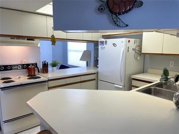 a room with stainless steel appliances a sink a stove and a refrigerator
