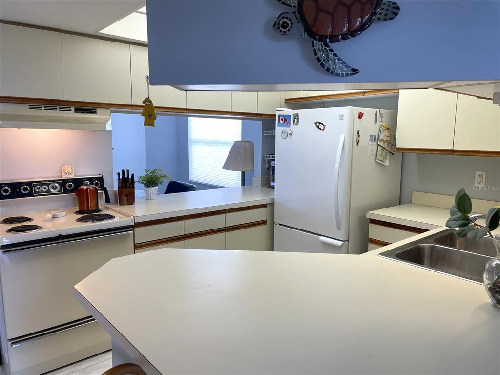 1401 South McCall Road, Unit 301A Englewood, FL 34223 - Photo 7 of 22 a room with stainless steel appliances a sink a stove and a refrigerator