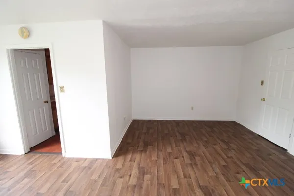 a view of a room with wooden floor and bench