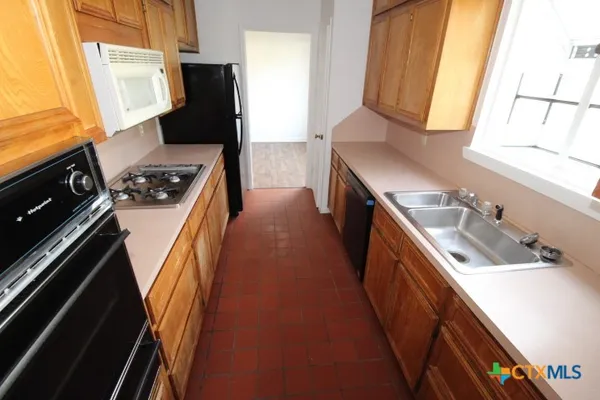 a kitchen with a sink a stove and a refrigerator