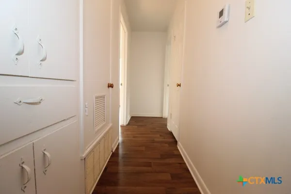a view of a hallway with wooden floor