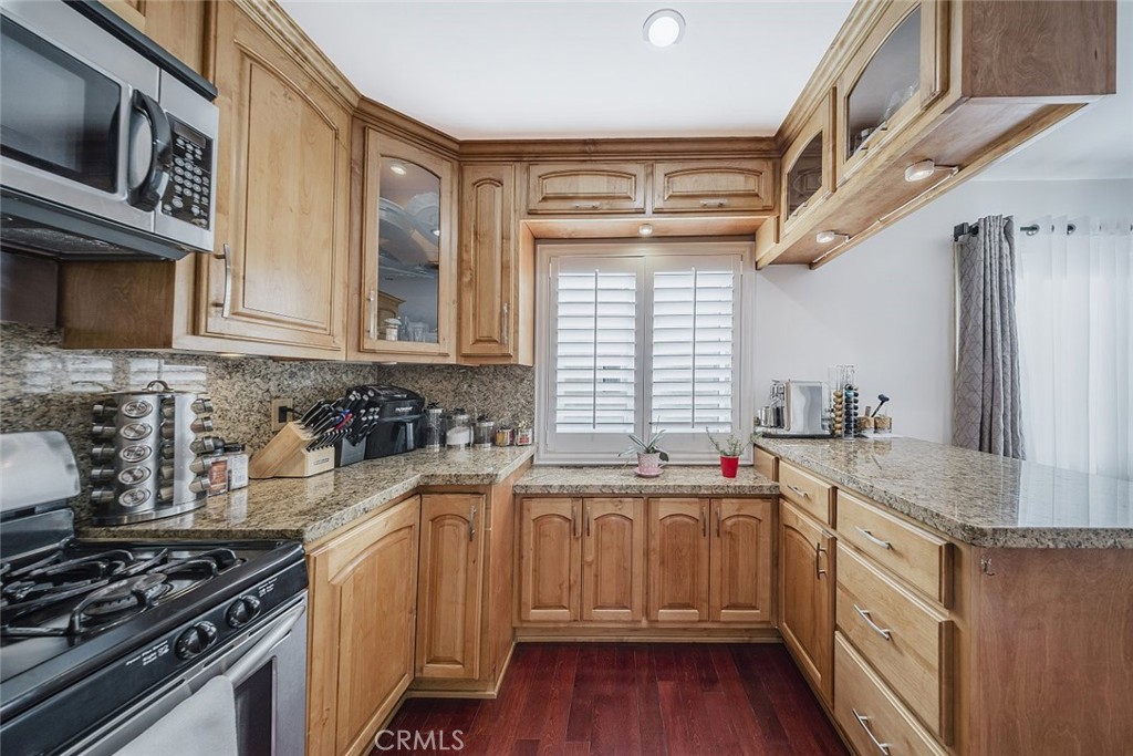 9775 Vía Roma Burbank, CA 91504 - Photo 12 of 39 a kitchen with stainless steel appliances granite countertop a sink stove and cabinets