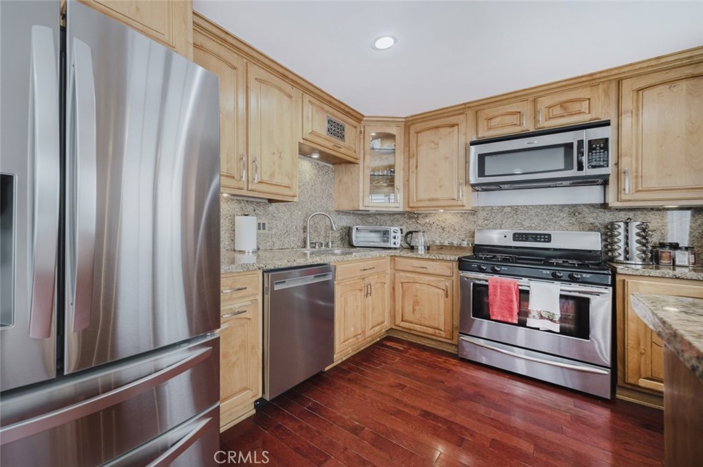 9775 Vía Roma Burbank, CA 91504 - Photo 14 of 39 a kitchen with stainless steel appliances granite countertop a refrigerator and a stove top oven