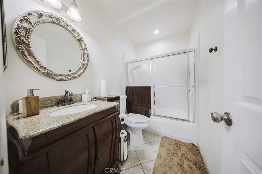 9775 Vía Roma Burbank, CA 91504 - Photo 32 of 39 a bathroom with a granite countertop sink mirror vanity and toilet