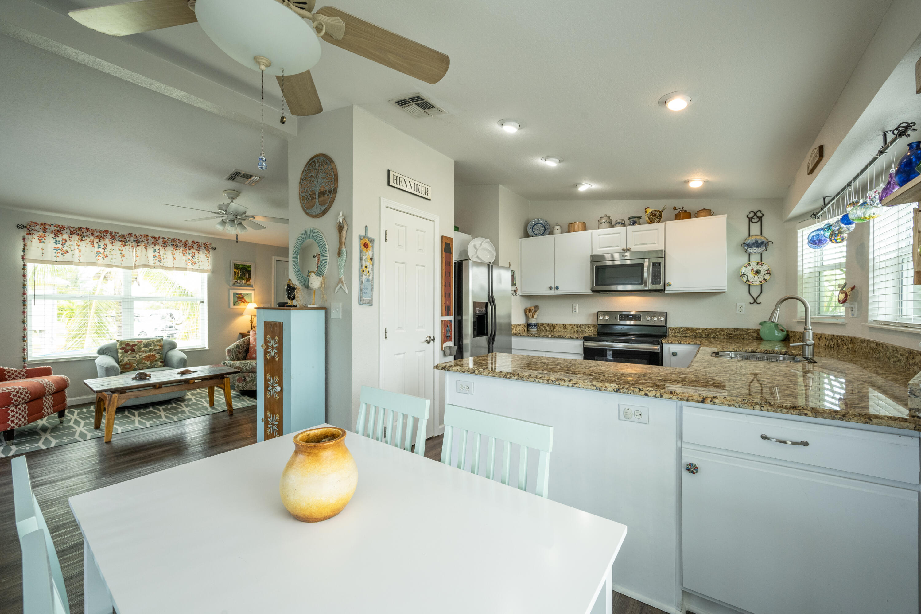 18 West Circle Drive Key West, FL 33040 - Photo 7 of 30 a kitchen with stainless steel appliances granite countertop a refrigerator a sink dishwasher a stove a dining table and chairs with wooden floor