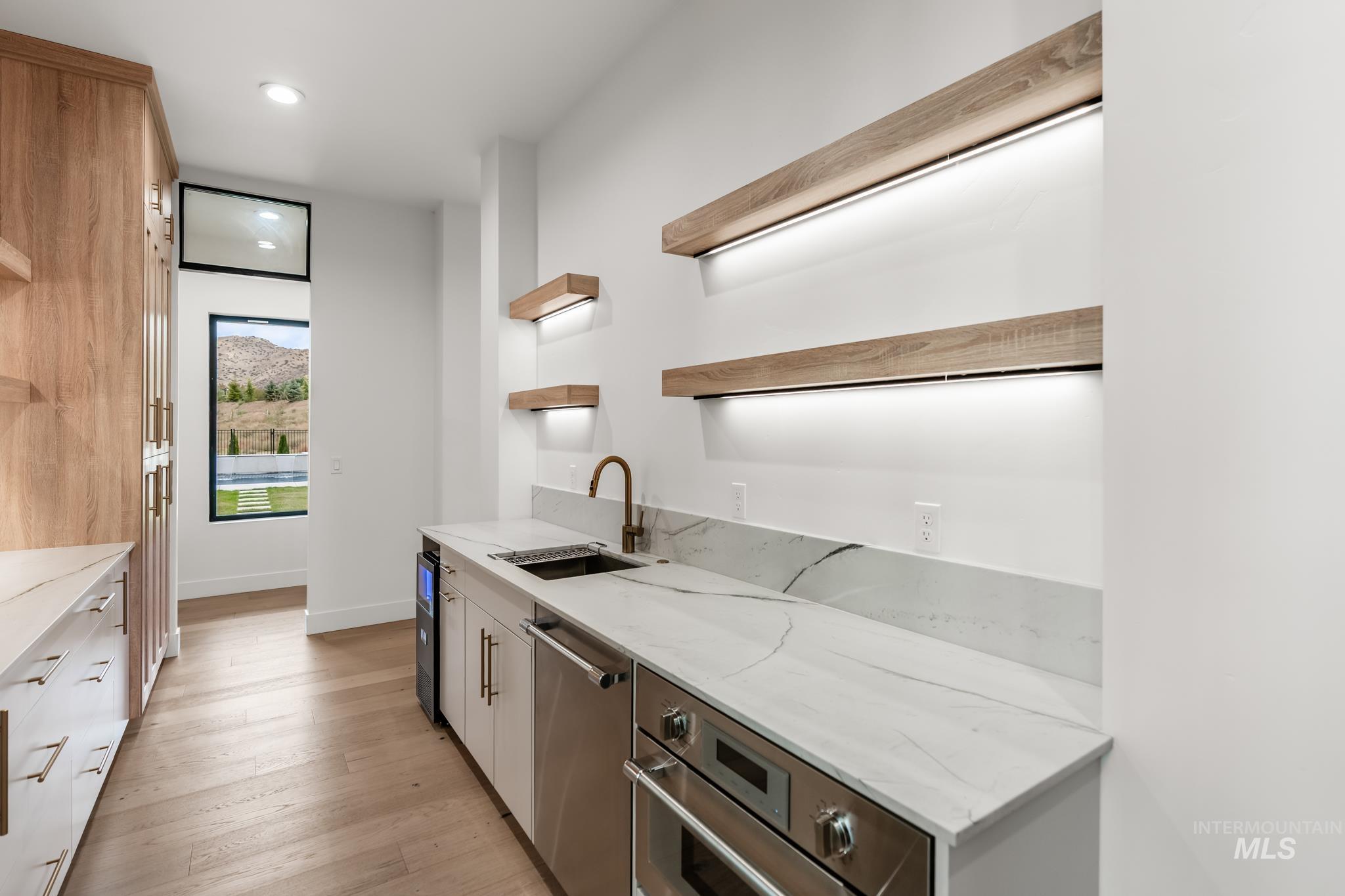 6162 North High Valley Way Boise, ID 83714 - Photo 20 of 50 Kitchen with open shelves, light stone counters, appliances with stainless steel finishes, light wood-style floors, and recessed lighting
