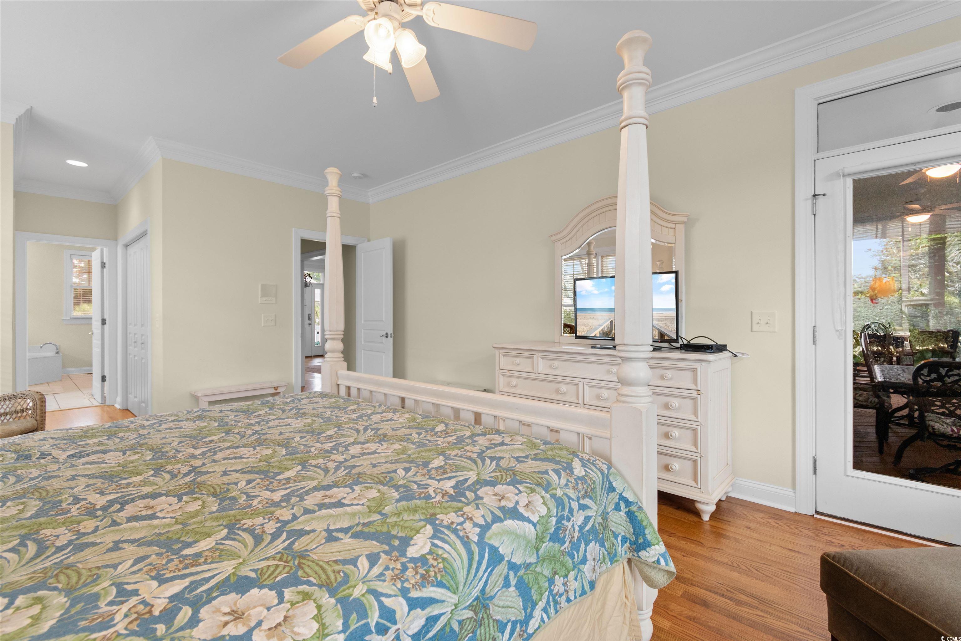 141 Cayman Loop Pawleys Island, SC 29585 - Photo 15 of 40 Bedroom featuring crown molding, light wood-type flooring, ensuite bathroom, and a ceiling fan