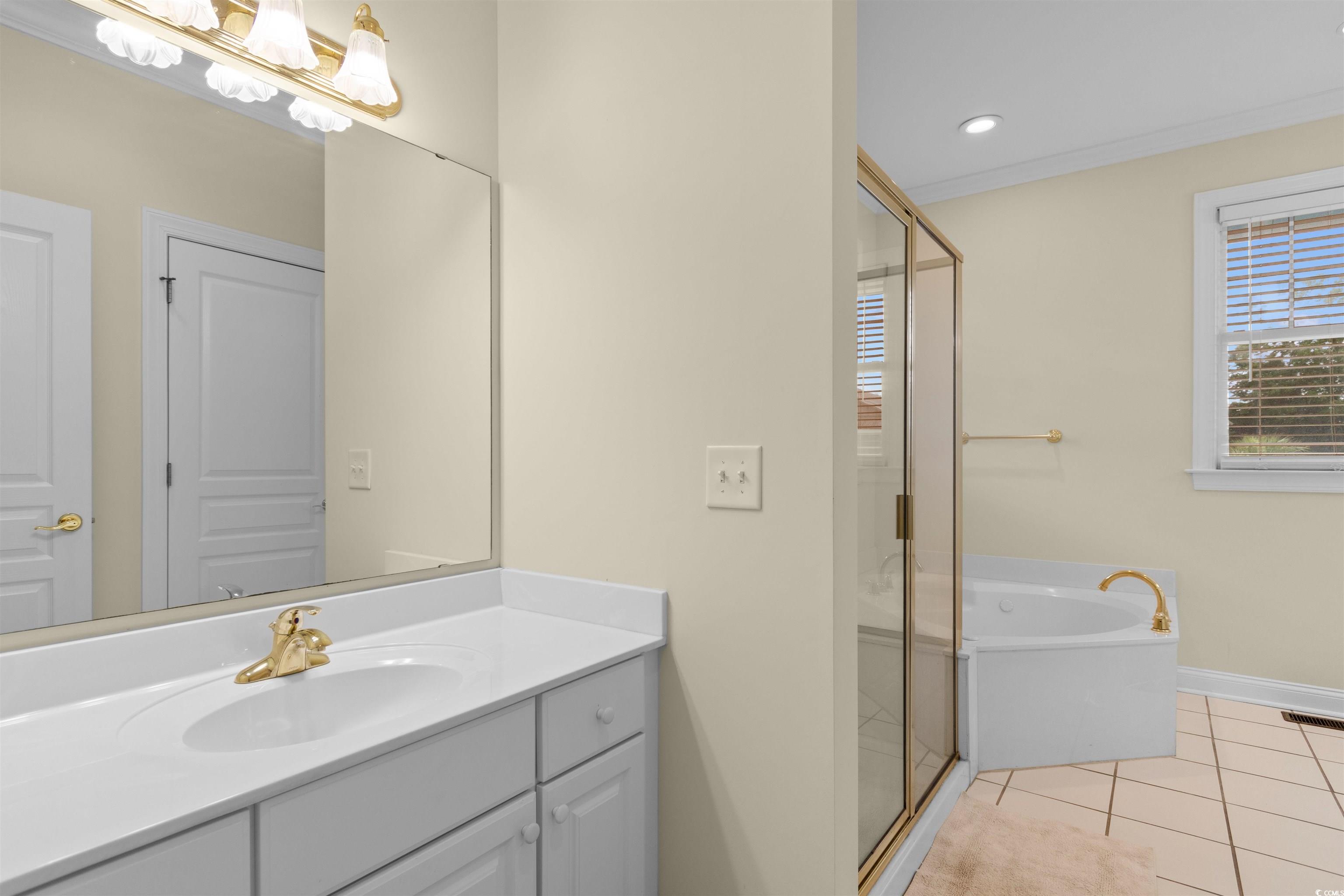 141 Cayman Loop Pawleys Island, SC 29585 - Photo 16 of 40 Full bathroom featuring a shower stall, vanity, a garden tub, baseboards, and tile patterned floors